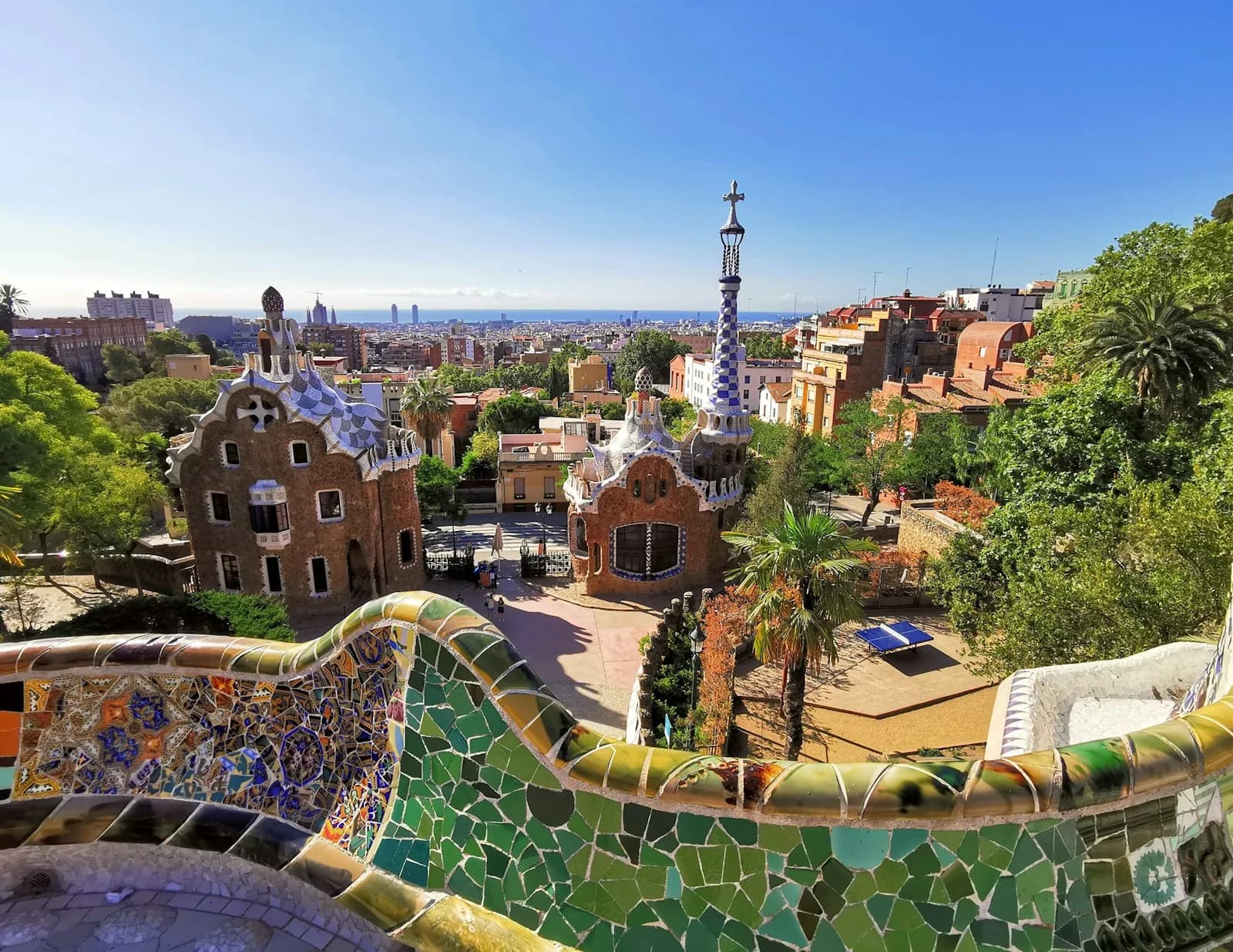 Panoramic view of Park Güell in Barcelona with the mosaic bench and city skyline